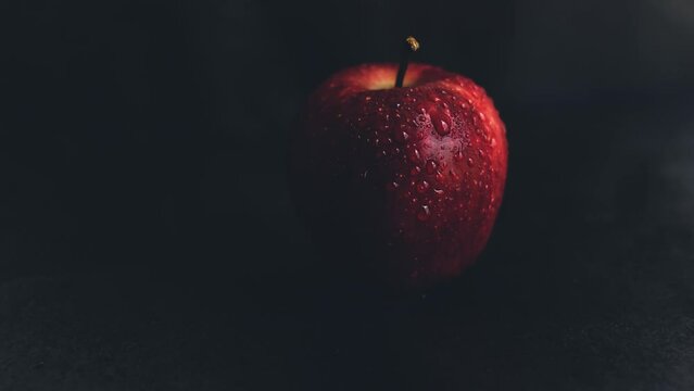 Forbidden fruit concept represented with a red apple on a black background with copy space, fruit of the sin