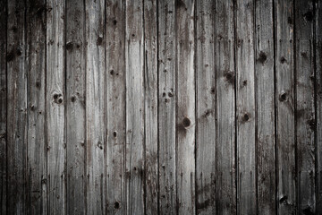 Old dark gray rustic wooden wall background planks weathered with nails