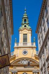Exterior view of the historical Dorotheerkirche Stadtkirche Church. Ancient tower among old town buildings in downtown Vienna, Austria, Central Europe. Viennese downtown neighborhood houses. 