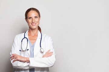 Friendly woman doctor in white uniform smiling looking at camera