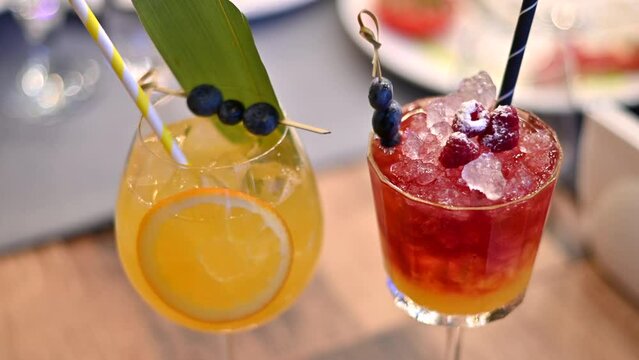 Orange and red cocktails, lemonade and vodca, mango juice, blueberries and ice