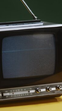 Retro TV with static white noise, not working, yellow and green background