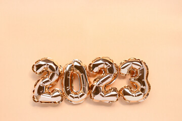 2023 golden balloons on a shiny background with copy space. Monochrome New Year's composition.