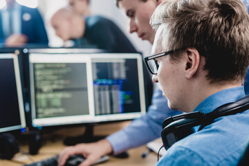 Startup business problem solving. Software developers working on desktop computer.