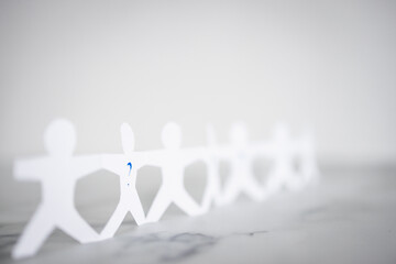 staff shortages and hiring personnel, paper people chain with question marks on some people symbol of positions to be filled