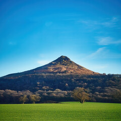 The fields and woodland slopes of Roseberry Topping near the North Yorks Moors, seen in bright,...