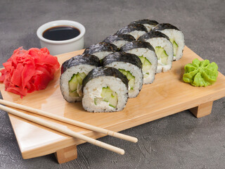 sushi rolls with cucumber and cream cheese on a wooden board