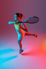 Aerial view. Training of female tennis player practicing power serving isolated on dark background in neon. Fitness, sport, achievements concept.