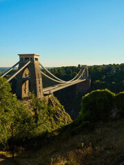 The famous Clifton Suspension Bridge at Bristol in dramatic side-lighting from a setting summer sun.