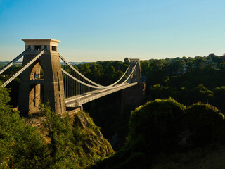 The famous Clifton Suspension Bridge at Bristol in dramatic side-lighting from a setting summer sun.