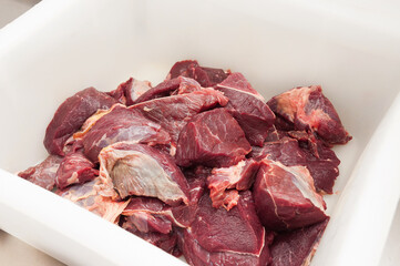 large pieces of beef in a plastic container. concept: meat production