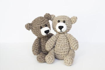 Crocheted gray and brown bears on a white background. Crocheted toy.