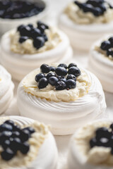 Rows of fresh mini pavlova meringue nests filled with mascarpone cheese