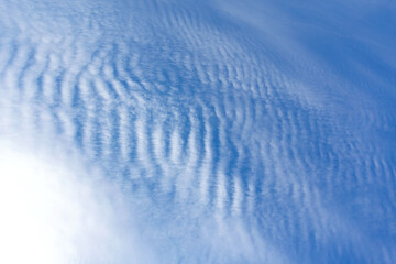 Fototapeta na wymiar White clouds like a sea wave shape in the light blue sky as background.