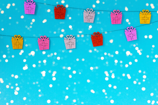 New Year Garland Of Gifts On A Light Blue Background In Blurred Lights