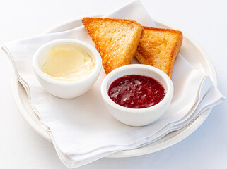 Toasted bread, strawberry marmalade and butter.