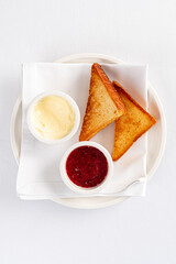 Toasted bread, strawberry marmalade and butter.