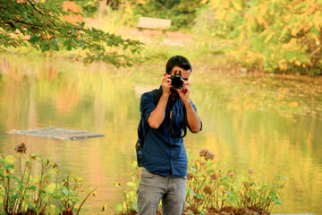 Obraz premium Male photographer in the forest. A traveling photographer in autumn colors. 