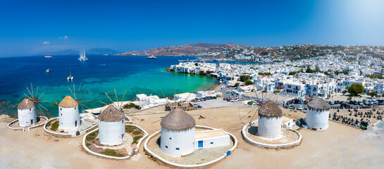 Panoramic view through the famous windmills above Mykonos town, Cyclades, Greece, to the Little Venice district - obrazy, fototapety, plakaty