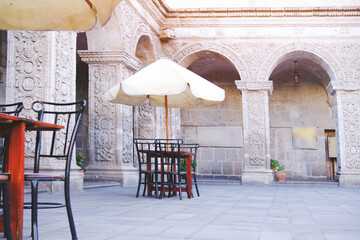Outdoor cafe on cobblestone street, Picturesque street with traditional houses and cafe tables in the city of Arequipa in Peru.