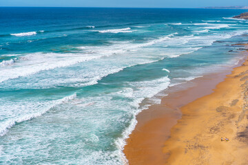 Fototapeta na wymiar Aerial view of tropical sandy beach and ocean with turquoise water with waves. Sunny day on Atlantic ocean beach