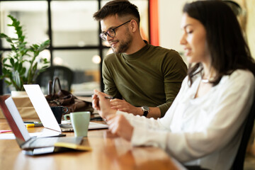 Colleagues in office. Businesswoman and businessman discussing work in office.