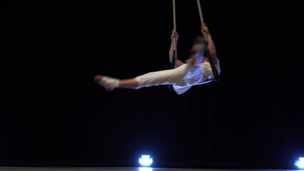 Muscular male air circus artist performances with dance trapeze 