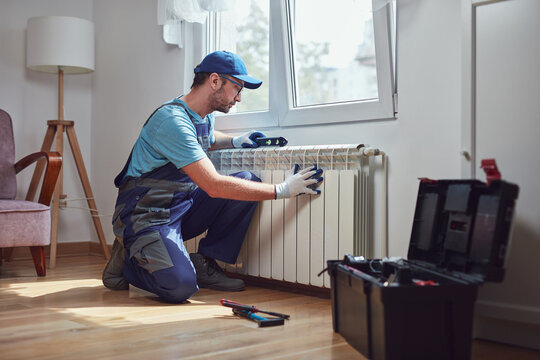 Central heating mechanic and handyman fixing home radiator, gas crisis and seasonal issues.