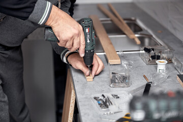 Handyman making kitchen wall cabinets in the apartment.