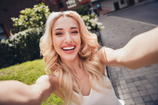 Photo of positive attractive lovely lady enjoy sightseeing town center make selfie video call outdoors