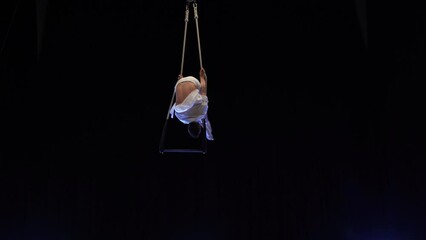 Muscular male air circus artist performances with dance trapeze. Concept of Individuality and creativity 