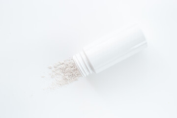 Fototapeta na wymiar Skin care with talcum powder in container. Spilled white powder