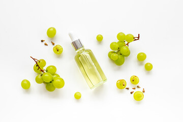 Bottle of grape seed oil with green grapes. Eco cosmetic product