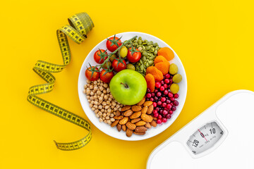 Heart shaped dish of fruits and healthy food with weight scale
