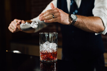 close up of barmen adding ice in glass
