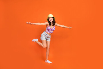 Full length photo of pretty charming lady purple swimwear arms sides having fun empty space isolated orange color background