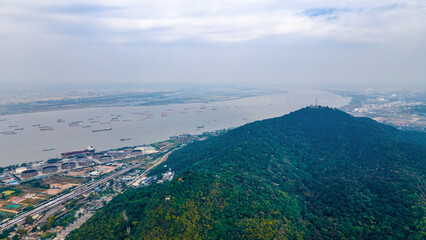 Fototapeta na wymiar Aerial photography of smog and industrial pollution shrouded in Qixia Mountain, the Yangtze River and busy transport ships in Nanjing City, Jiangsu Province, China