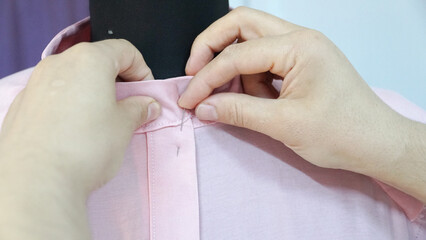 woman sewing shirt on mannequin