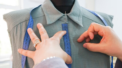 woman sewing shirt on mannequin