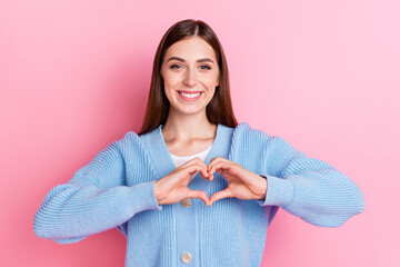 Photo of nice cute attractive stylish girl dressed blue cardigan cheerful smiling showing heart gesture isolated on pink color background