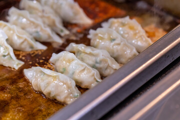 中華料理店の厨房で餃子を焼く