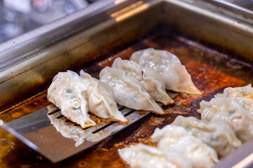 中華料理店の厨房で餃子を焼く