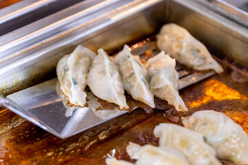 中華料理店の厨房で餃子を焼く