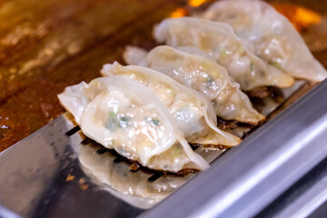 中華料理店の厨房で餃子を焼く