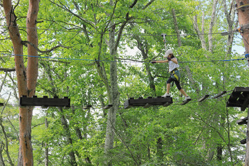 木の上のアスレチックで遊ぶ女子小学生 (7歳)