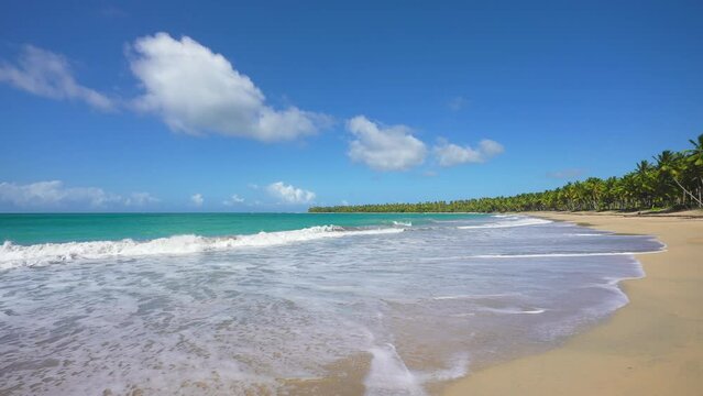 Sunny summer day in the Indian Ocean near the sandy beach. Palm beach with yellow sand. Landscape of sky and sea beach. Panoramic camera movement.