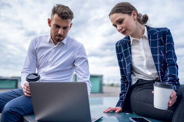 Male and female entrepreneurs analyzing data on laptop