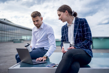 Male and female entrepreneurs analyzing data on laptop