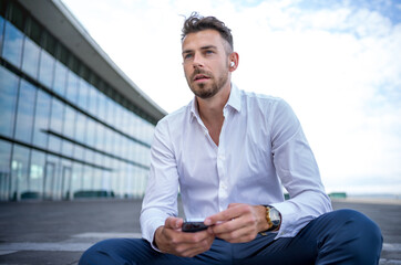 Male manager listening to music on steps