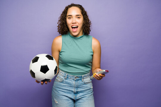 Studio Shot Of A Young Woman Cheering For Her Favorite Soccer Team